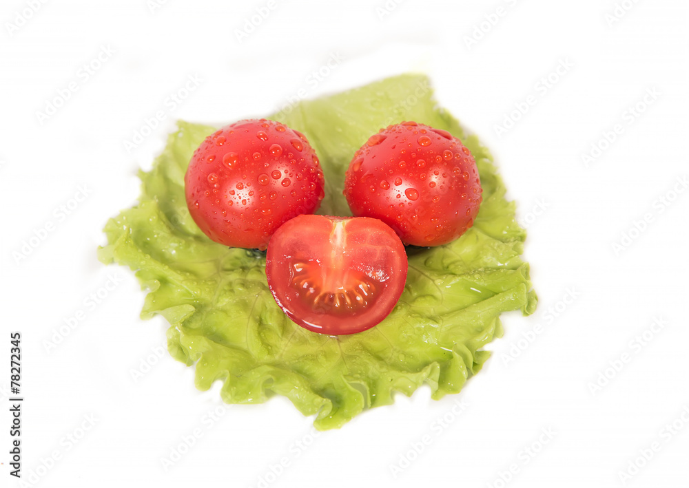 chopped tomatoes lying on a sheet of green salad chopped tomatoes lying on a sheet of green salad
