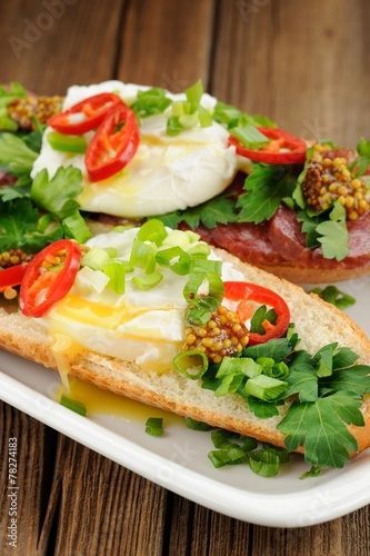 Poached egg sandwiches with chili, scallion and salami