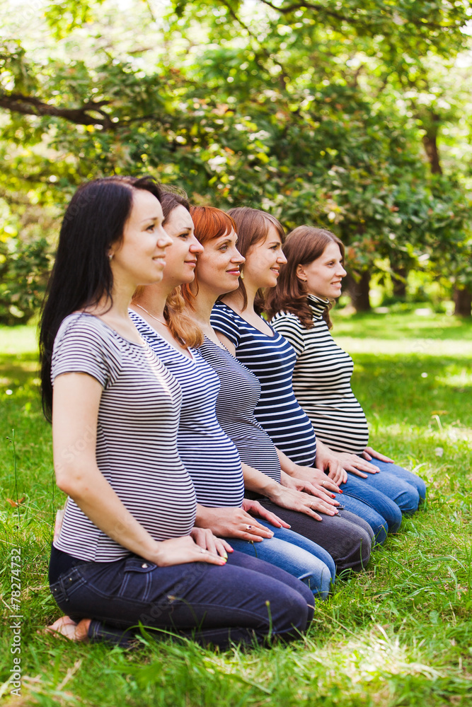 Fototapeta premium Group of pregnant women wearing the same clothes and sitting on