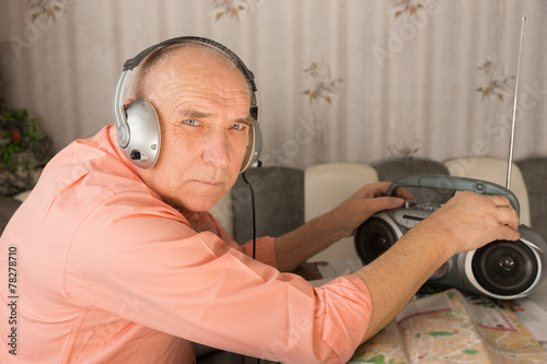 Elderly Listening Radio While Looking at Camera photo