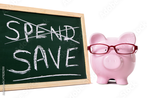 Piggy Bank or piggybank wearing glasses with small blackboard showing spend and save advice message isolated on white background photo