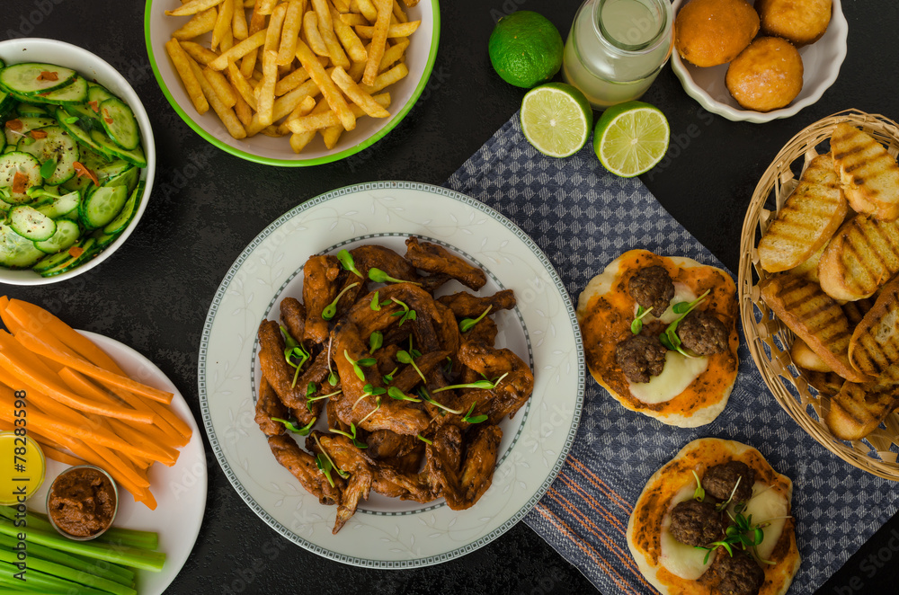 Sports feast - chicken wings, vegetable, french fries, pizza Sports feast - chicken wings, vegetable, french fries, pizza