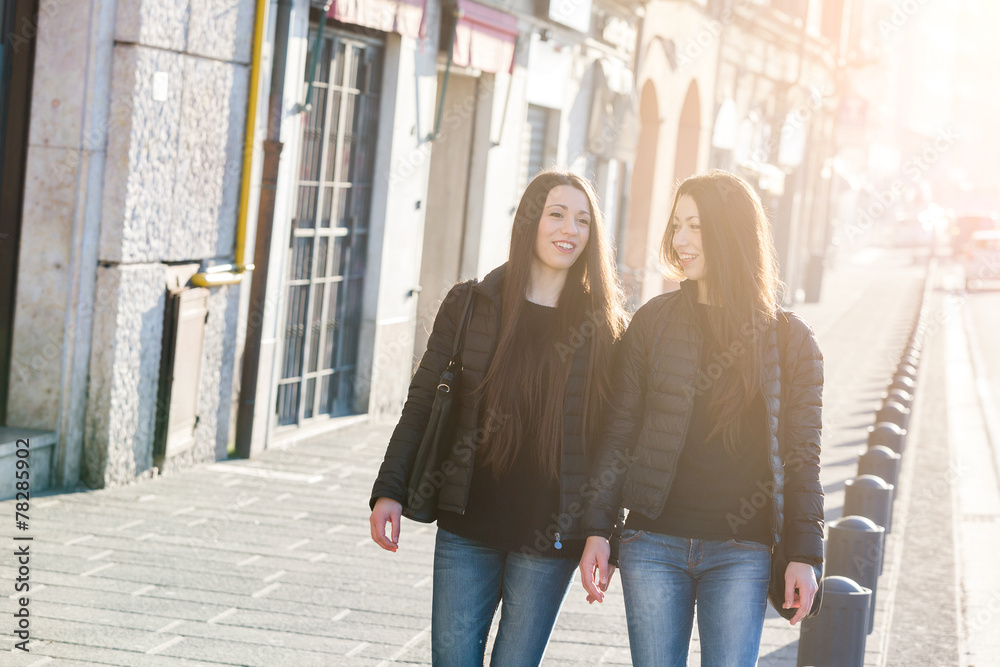 Female Twins Walking on Sidewalk in the City