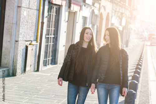 Female Twins Walking on Sidewalk in the City