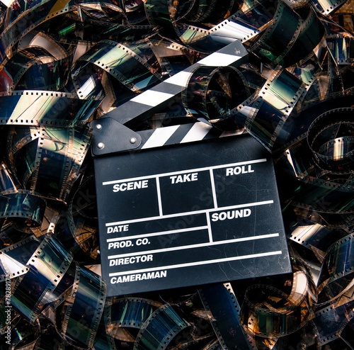 Bilde på lerret Unrolled heap 35mm movie filmstrip color carpet and clapperboard
