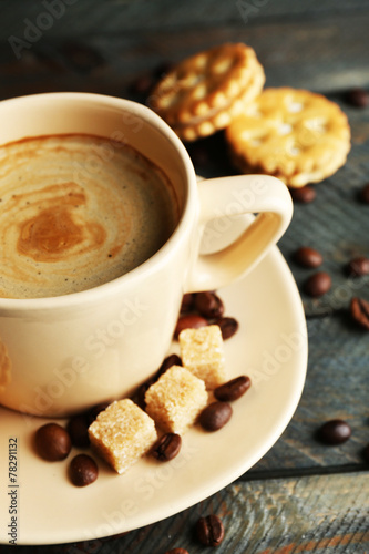 Cup of coffee and tasty cookies on wooden background