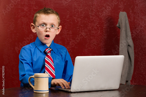 Young frightened boy on working on computer.