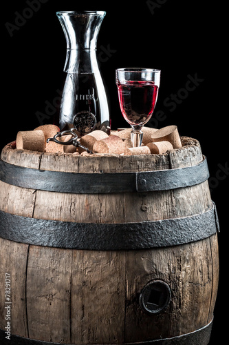 Red wine glass and carafe on old wooden barrel