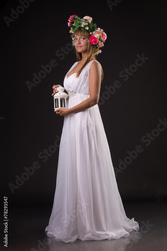 girl as  fairy in white dress and wreath of flowers on the head