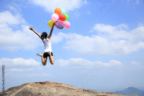 young asian woman mountain peak with colored balloons 