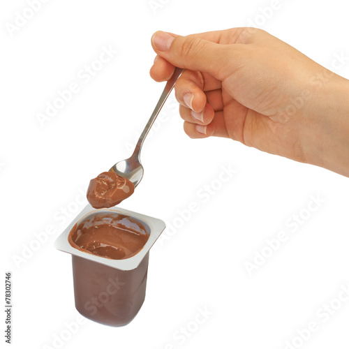 Spoon with chocolate pudding, coffee, baby food in hand on a whi