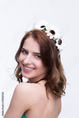 Smiling beautiful woman with wreath over gray background