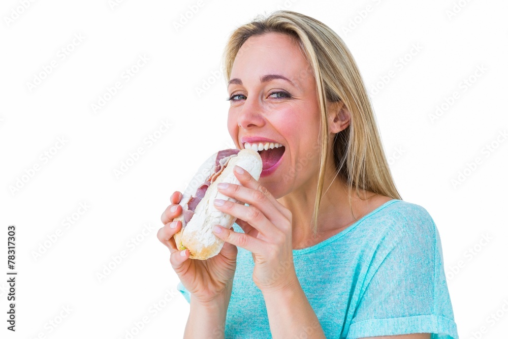 Smiling blonde eating sandwich and looking at camera Smiling blonde eating sandwich and looking at camera