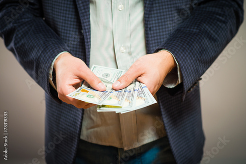 Business executive in formal suit giving money as a bribe