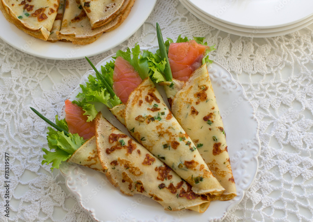 Thin rolled pancakes, crepes with salmon, . Traditional Russian