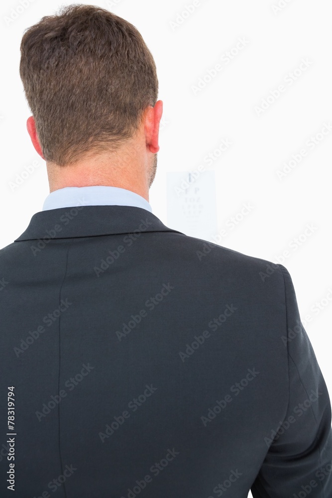 Focused man in suit on eye test letters Focused man in suit on eye test letters