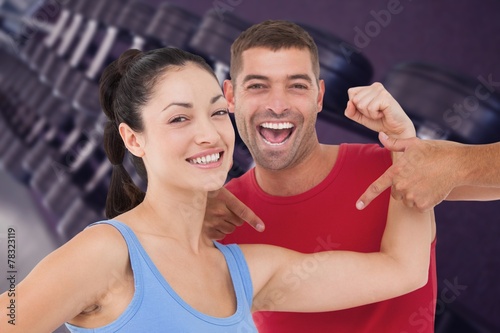 Composite image of fit woman and trainer smiling at camera