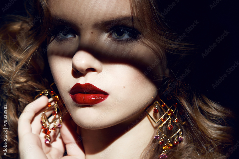 Fototapeta premium Beautiful sexy woman party makeup gold earrings red lips shadows