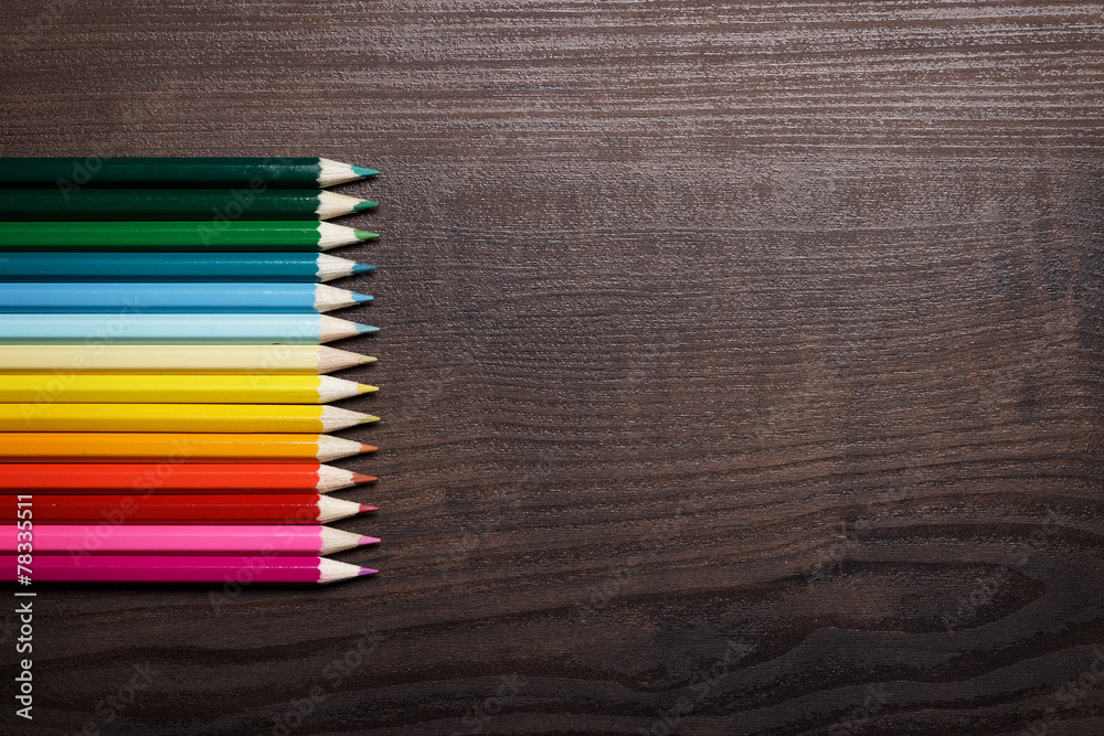 multicolored pencils over brown table background multicolored pencils over brown table background