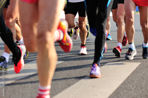 marathon runner legs running on city street © lzf
