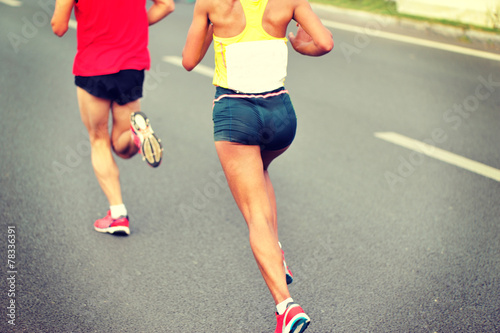 marathon runner legs running on city street