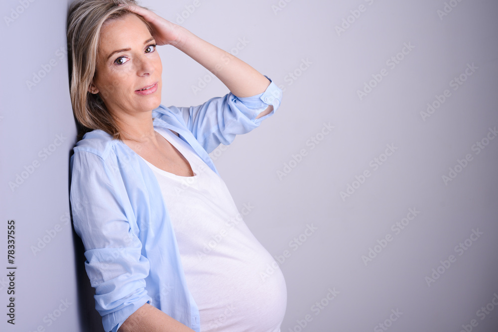 beautiful forty years old pregnant woman on gray background beautiful forty years old pregnant woman on gray background
