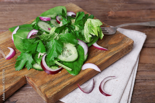 Mix salad leaves with sliced cucumber and onion