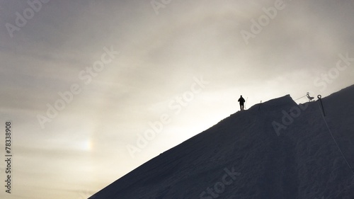 Hiking silhouette at the sunset on a snowy mountain  photo