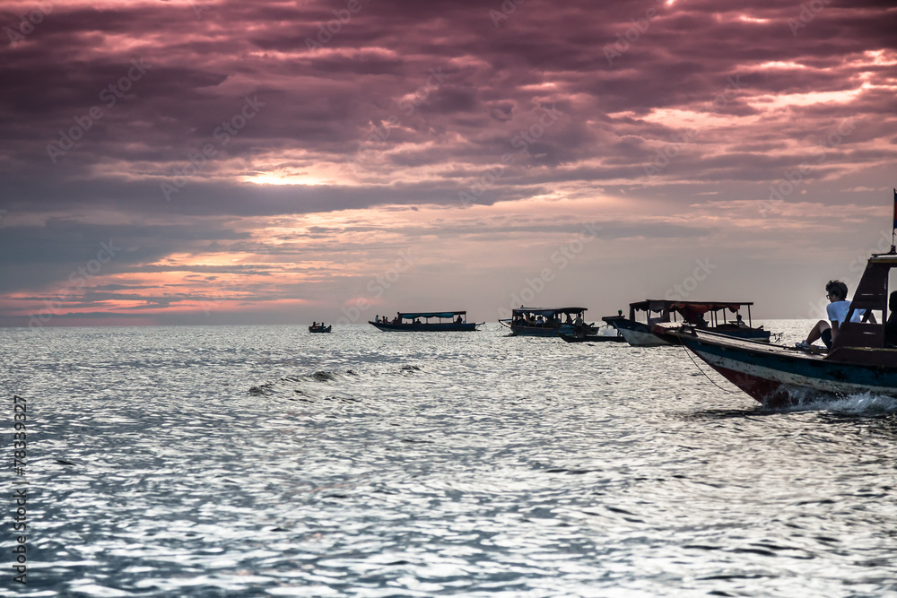 Obraz premium Boats sail towards the sunset