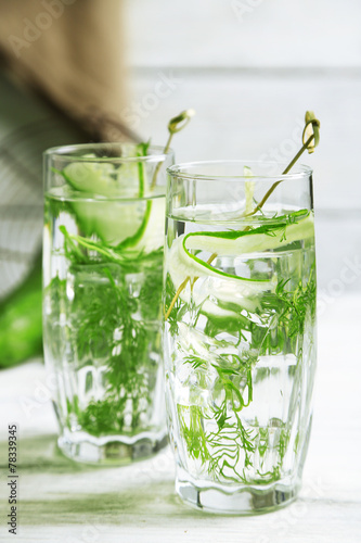 Glasses with fresh organic cucumber water on wooden table