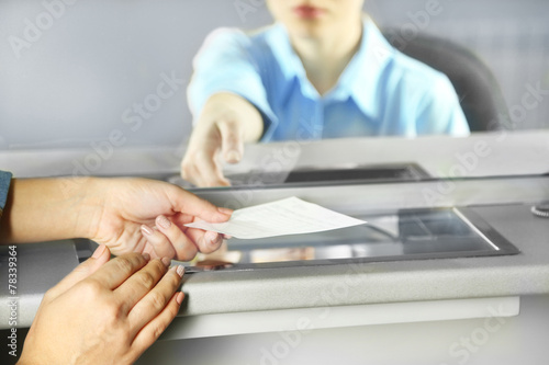 Teller window with working cashier. Concept of payment of