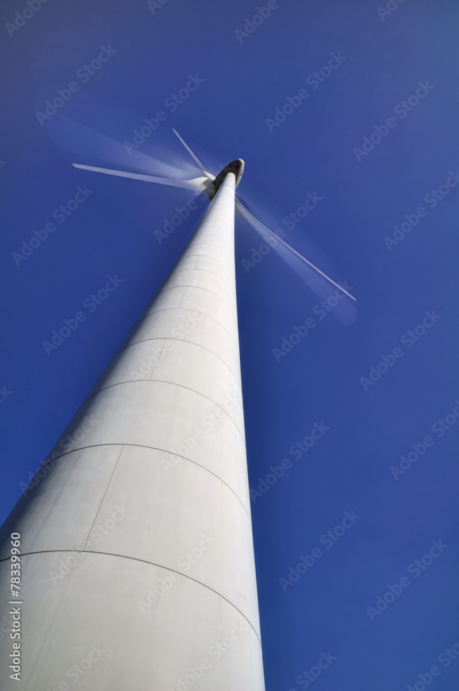Naklejka premium Pales d'une éolienne en mouvement avec un ciel bleu