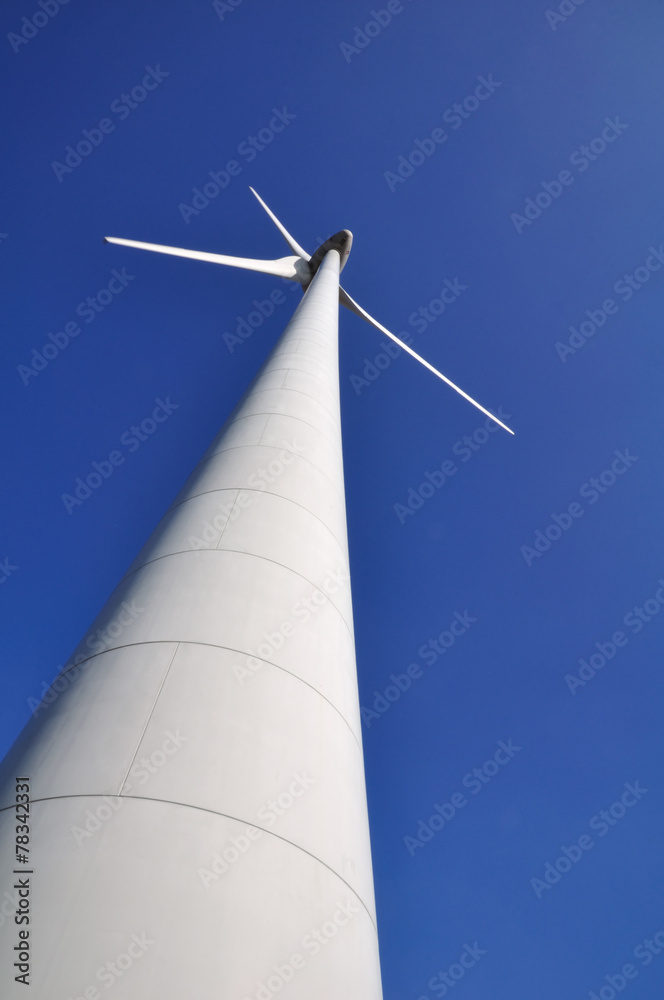 Eolienne avec ses pales arrêtées sur fond de ciel bleu Eolienne avec ses pales arrêtées sur fond de ciel bleu