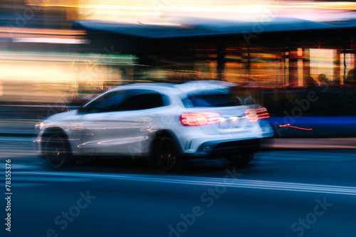 White SUV Car in a Blurred City Scene