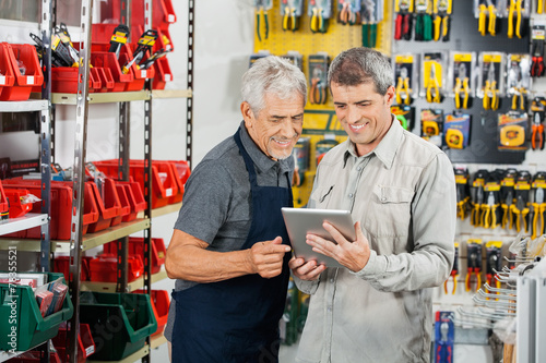 Fototapeta Salesperson And Customer Using Tablet Computer