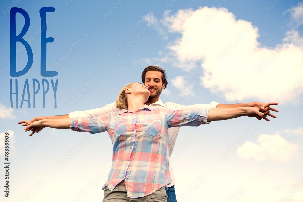 Happy couple standing outside with arms stretched kissing Happy couple standing outside with arms stretched kissing