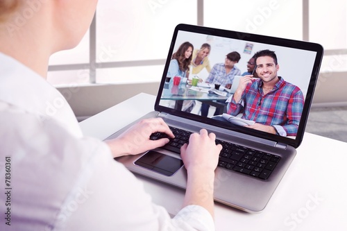 Composite image of businesswoman using her laptop