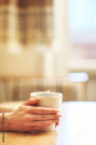 Hands with cup of hot morning coffee