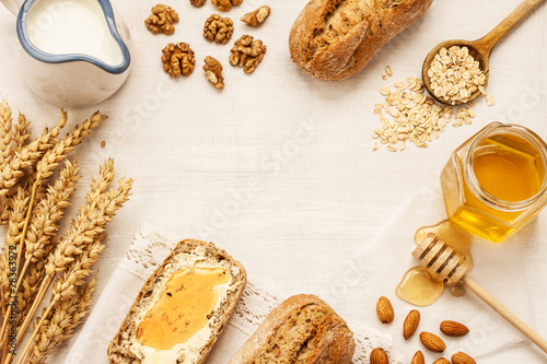 Rural or country breakfast - bread rolls, honey jar and milk
