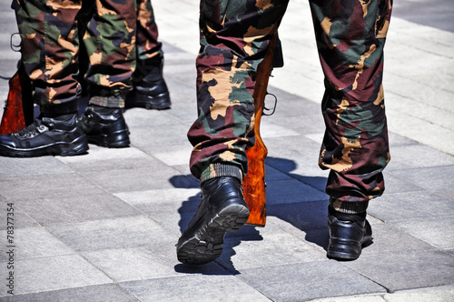 Military soldiers' legs in camouflage uniform