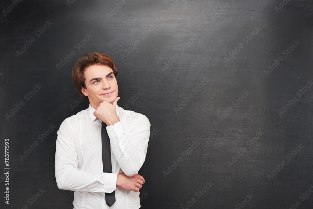 Smiling young man on chalkboard background Smiling young man on chalkboard background
