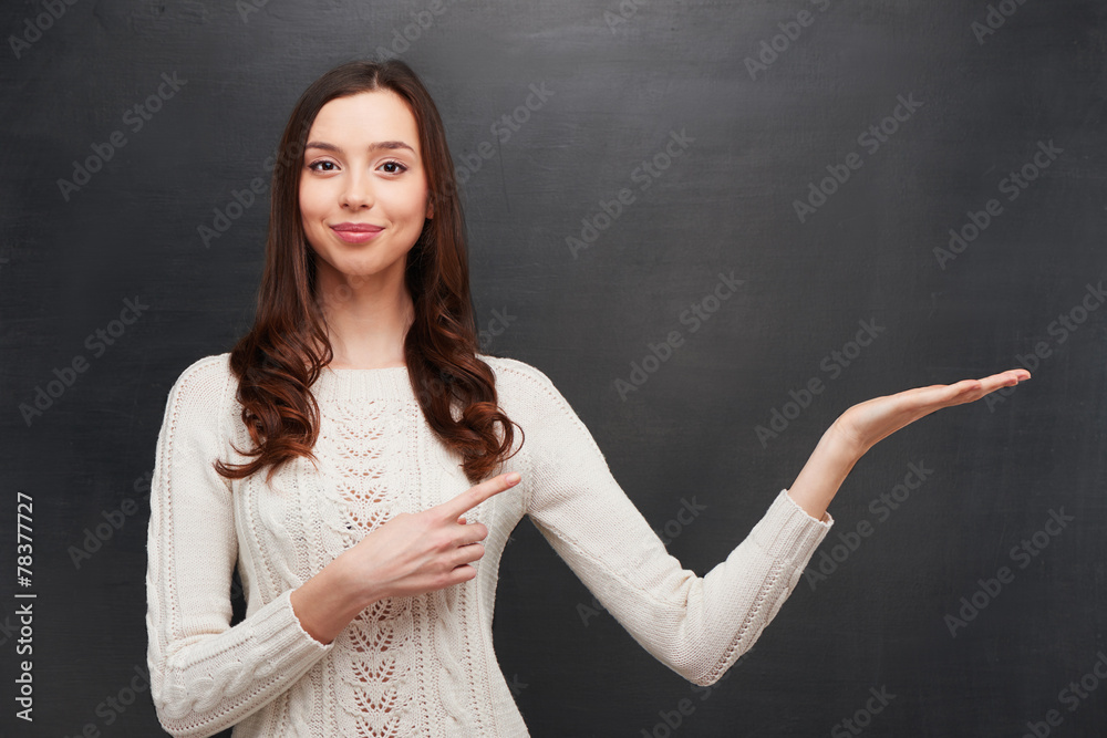 Smiling woman pointing at chalkboard Smiling woman pointing at chalkboard