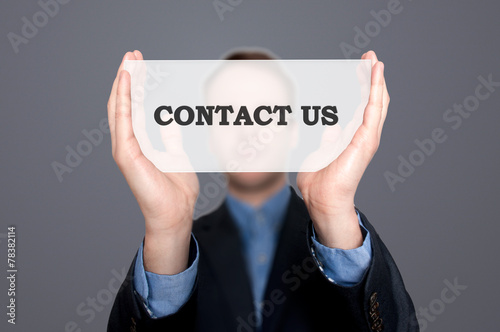 Businessman Holding Sign Contact Us. Grey background