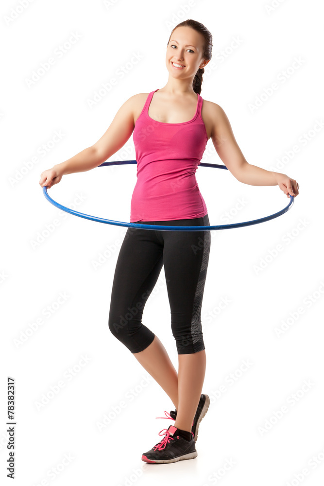 Young woman standing with hula hoop round her waist Young woman standing with hula hoop round her waist
