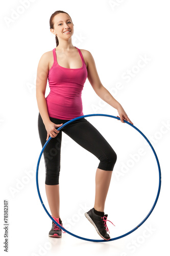 Young woman standing with hula hoop down