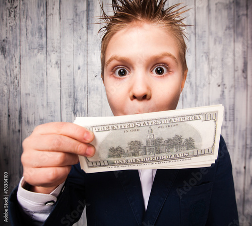 Portrait of happy boy with dollar bills looking at camera