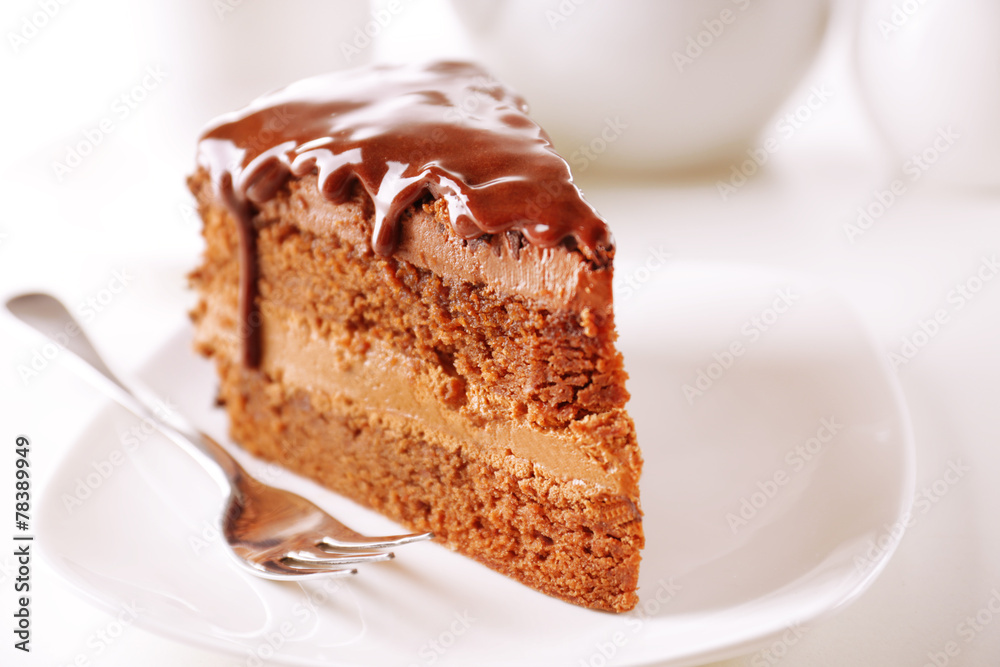 Delicious chocolate cake on plate on table on light background Delicious chocolate cake on plate on table on light background