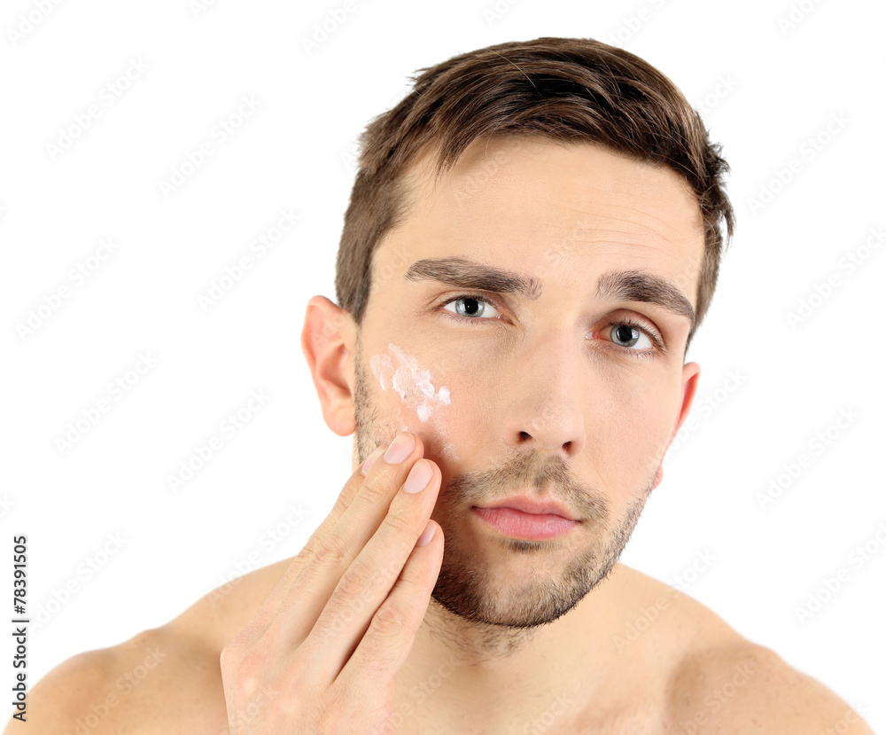 Handsome young man applying cream lotion Handsome young man applying cream lotion