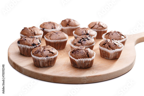 Delicious chocolate muffins on wooden board 