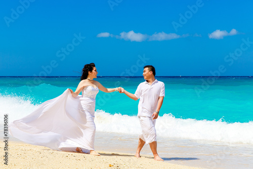 Asian bride and groom on a tropical beach. Wedding and honeymoon © frolova_elena
